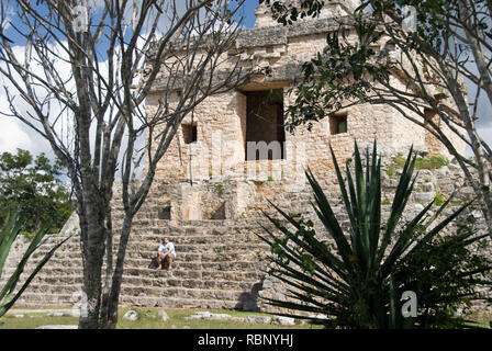 Mexique - 16 Jan 2007 : Jeune homme s'assit sur les marches du Temple du Soleil ou sept poupées encadrée par le feuillage à Dzibilchaltún, près de Mérida Banque D'Images