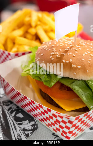 Burger végétarien, avec espace pour texte dans étiquette vide (drapeau) . Viande vegan. Flou artistique sur l'arrière-plan flou frites. Banque D'Images