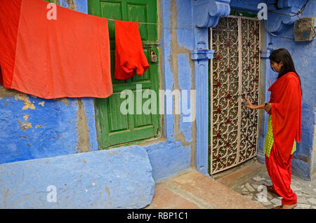 Femme fermeture porte de blue house, Jodhpur, Rajasthan, Inde, Asie Banque D'Images