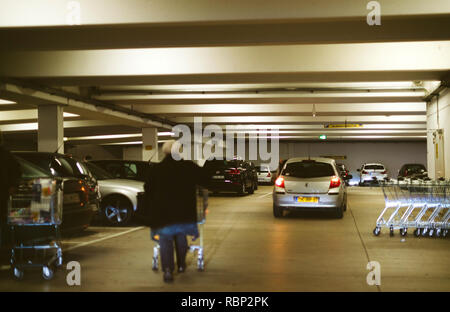 Francfort, Allemagne - DEC 21, 2016 : Piscine supermarché avec man pushing shopping panier d'épicerie, un parking voitures Banque D'Images