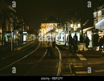 STRASBOURG, FRANCE - DEC 23, 2016 : les piétons traversant street dans la ville de Strasbourg dans la nuit avec un marché de Noël dans l'arrière-plan Banque D'Images