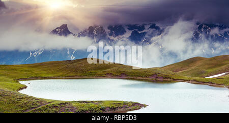 Paysage fantastique avec le lac Koruldi et ciel couvert au pied de Mt. Ushba. Haut Svaneti, Mestia, la Géorgie, l'Europe. Montagnes du Caucase. Beauté w Banque D'Images