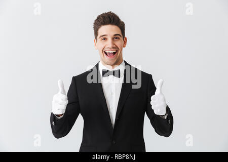 Portrait d'un beau jeune homme garçon portant des gants et tuxedo isolés sur fond blanc Banque D'Images