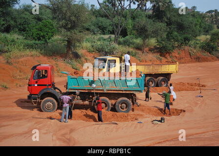 Une équipe de travail au Niger, en Afrique, le chargement sur les camions à benne de sable à la main Banque D'Images