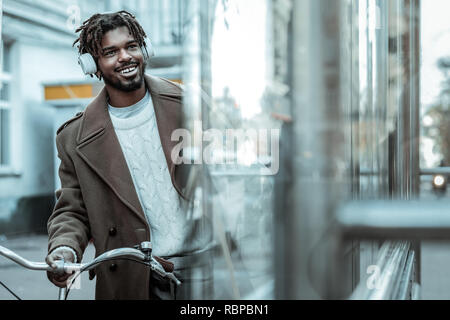 Cheerful la peau sombre man looking at shop window Banque D'Images