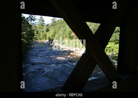 Avis de Swift River dans la région de White Mountains National Forest, Albany, New Hampshire. Tourné à partir de pont couvert d'Albany,montrant la structure du pont en bois couvert Banque D'Images