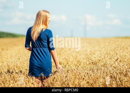 Belle femme marche dans champ de blé. Banque D'Images