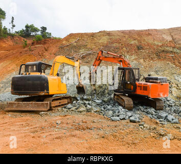 Une perforatrice pneumatique briser tout en granit d'une excavatrice recueille la pierre pour le chargement. Image industrielle. Exploitation minière et de la construction. Banque D'Images