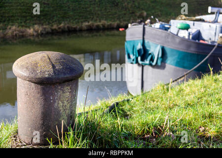 Une barge est lié à un poste d'amarrage sur un canal de Gand, Belgique Banque D'Images