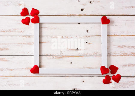 Immersive saint-valentin concept.cadre blanc décoré avec des coeurs sur la table en bois blanc. Copyspace Banque D'Images