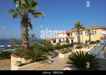 Athitos, Grèce - septembre 3, 2013 : vue sur le bâtiment jaune, le bleu de la mer et le vert des palmiers dans l'hôtel, péninsule de Kassandra, Grèce. Banque D'Images