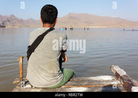 Un jeune homme est assis sur la petite jetée du lac Urmia, province de l'Ouest, l'Iran Banque D'Images