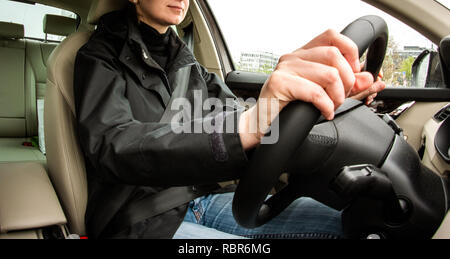 Jeune femme au volant de voiture de luxe - vue de l'intérieur avec lentille ultra-large Banque D'Images