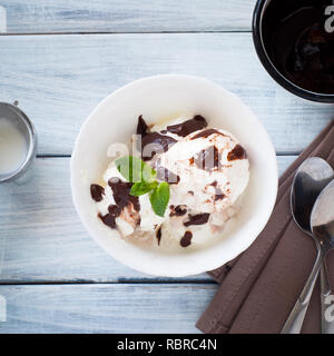 Glace vanille, garnie de chocolat dans le bol blanc. Banque D'Images