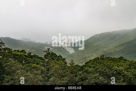 Hong Kong, Chine - 12 mai 2010 : à la recherche de Victoria le sommet de la montagne sur la mer de Chine du Sud dans le brouillard. Les immeubles de grande hauteur en bas au bord de la mer. Banque D'Images