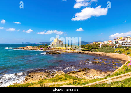 Côtes de la Méditerranée dans la ville d'Alghero, Sardaigne, Italie. Les fleurs du printemps et les arbres sur le premier plan, les bâtiments colorés du vieux centre-ville d'Alghero sur bac Banque D'Images