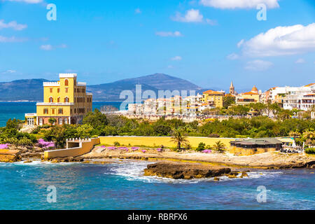 Côtes de la Méditerranée dans la ville d'Alghero, Sardaigne, Italie. Les fleurs du printemps et les arbres sur le premier plan, les bâtiments colorés du vieux centre-ville d'Alghero sur bac Banque D'Images