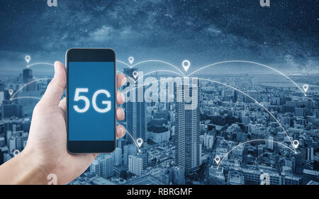 La technologie 5G, la main à l'aide d'5g internet sur mobile smartphone et la ville avec la mise en réseau Banque D'Images