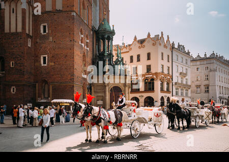 Cracovie, Pologne - 28 août 2018 : Deux chevaux en vieux chariot entraîneur à la place de la vieille ville en journée ensoleillée. La basilique Sainte-Marie célèbre Landma Banque D'Images