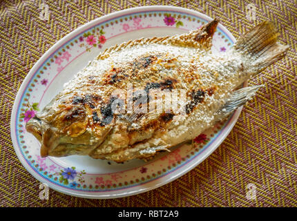 Grillades de poissons tilapia tilapia Cook avec du sel dans l'alimentation de style asiatique sur platine - Gravure de poisson Tilapia thaïlandais aux herbes brûlées Banque D'Images