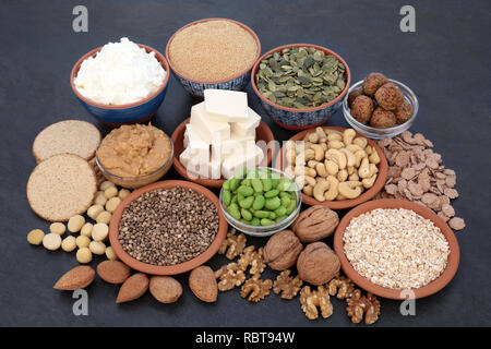 Nourriture santé pour les végétaliens avec beurre d'amandes et du yogourt, du tofu caillé, céréales, graines, noix, fèves edamame, boules de quinoa, l'avoine craquelins et céréales. Banque D'Images