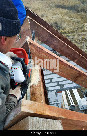 Couper les travailleurs les chevrons sur le toit de la tronçonneuse house Banque D'Images