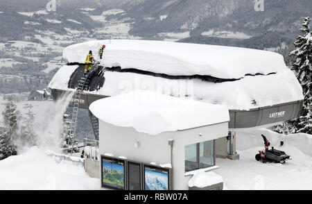 12 janvier 2019, la Bavière, Schönau am Königssee : Les pompiers déneiger le toit d'une station des remontées mécaniques de la Jennerbahn. Photo : Tobias Hase/dpa Banque D'Images