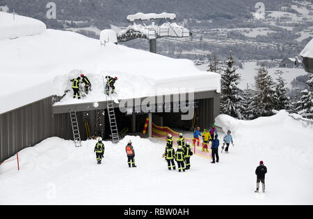 12 janvier 2019, la Bavière, Schönau am Königssee : Les pompiers déneiger le toit d'une station des remontées mécaniques de la Jennerbahn. Photo : Tobias Hase/dpa Banque D'Images