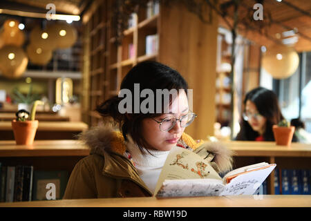 Chongqing, China's Chongqing. Jan 11, 2019. Une femme lit un livre dans une bibliothèque dans le Beicang créatif culturel & quart sud-ouest de la Chine, Chongqing, du 11 janvier 2019. Beicang créatifs culturels & Trimestre, situé dans le quartier de Jiangbei du sud-ouest de la municipalité de Chongqing, est rénové à partir d'un ancien entrepôt de textile. Le trimestre se compose de plusieurs sections, dont une bibliothèque publique, entreprises de loisirs et de zones de bureau. Il conserve l'architecture industrielle de style des années 1950 et 1960, attirant de nombreuses personnes à visiter. Credit : Wang Quanchao/Xinhua/Alamy Live News Banque D'Images