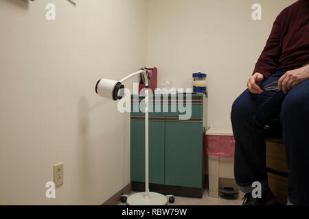 Une femme dans la salle d'examen attend d'être vu par son médecin. Banque D'Images