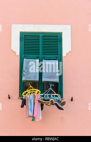 Fenêtre traditionnelle avec des volets en bois de la vieille maison. Blanchisserie suspendu à Windows en Orbetello. Italie Banque D'Images