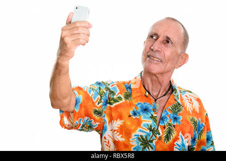 Studio shot of happy senior man smiling tout en tenant pict selfies Banque D'Images