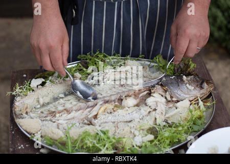 En anglais Chef restaurant servant des gros poissons préparés sur le plateau avec salade Banque D'Images