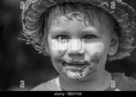 Un B&W portrait d'un jeune garçon portant un chapeau robuste Banque D'Images