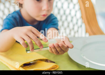 Garçon en utilisant un désinfectant pour les mains de lavage gel dans les cafe. Banque D'Images