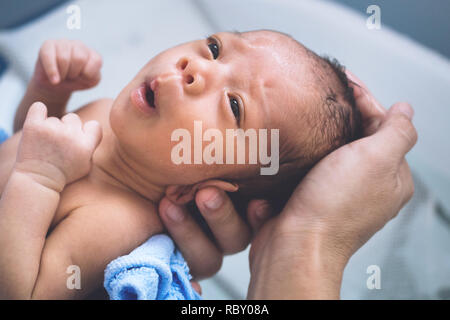 Happy asian baby boy une sensation de froid pour prendre le bain à la première fois de la vie. mother holding et le bain de bébé nouveau-né dans la matinée. bébé vie con