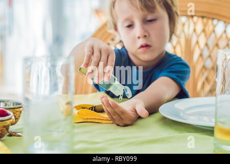 Garçon en utilisant un désinfectant pour les mains de lavage gel dans les cafe. Banque D'Images