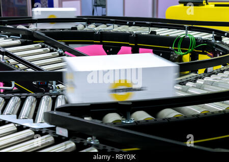 Boîte en carton blanc de l'emballage du produit déménagement sur la courroie du convoyeur de l'emballage automatique de la machine en usine de fabrication prêt pour distribution à marke Banque D'Images