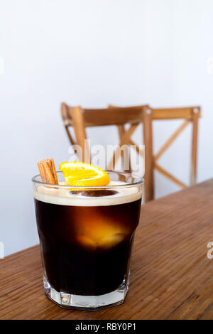 Préparer le café froid avec du citron et la cannelle servir sur table et chaises en bois au café du matin. populaires menu café glacé en été. Banque D'Images