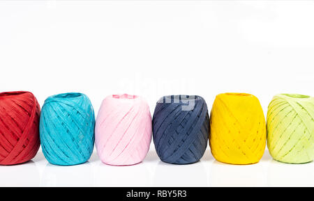 Quelques balles de raphia de couleur sur une surface blanche Banque D'Images