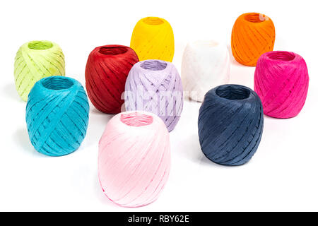 Quelques balles de raphia de couleur sur une surface blanche Banque D'Images