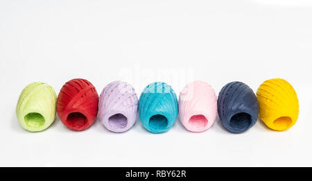 Quelques balles de raphia de couleur sur une surface blanche Banque D'Images