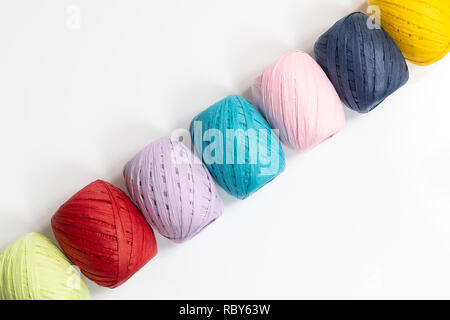 Quelques balles de raphia de couleur sur une surface blanche Banque D'Images