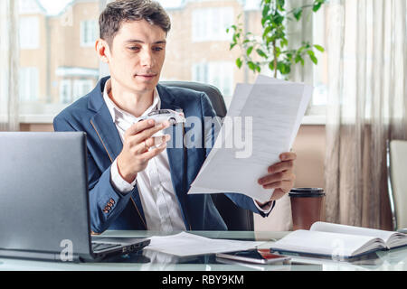 Agent Man holding a toy voiture et les documents d'enregistrement de la voiture à l'office. Le concept de l'achat et vente de voitures de transport Banque D'Images