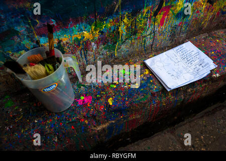 Nettoyer les brosses et une affiche croquis sont vu placé sur un trottoir éclaboussé sur le signe de l'atelier de peinture à Cartagena, Colombie. Banque D'Images