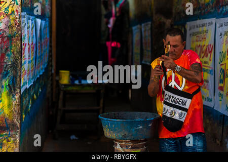 José Corredor ("Runner") nettoie ses pinceaux de peinture dans l'atelier de peinture signe à Cartagena, Colombie. Banque D'Images