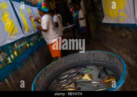 Les brosses de peinture sont vus flottant dans le bassin d'eau de rinçage dans le signe de l'atelier de peinture à Cartagena, Colombie. Banque D'Images