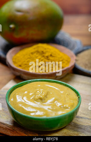 Mangue-curry sauce savoureuse dans un petit bol prêt à manger et des bols à la mangue et curry en poudre fermer- up Banque D'Images