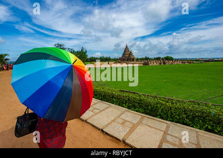 Une femme avec un parasol de couleur vive à la Monuments de Mahabalipuram près de Chennai, Inde Banque D'Images