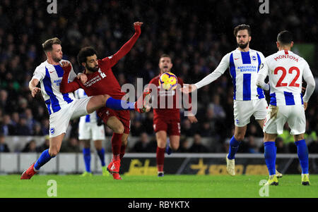 Brighton & Hove Albion's Dale Stephens (à gauche) et de Liverpool, Mohamed Salah (centre) bataille pour la balle durant le match à la Premier League stade de l'AMEX, Brighton. Banque D'Images